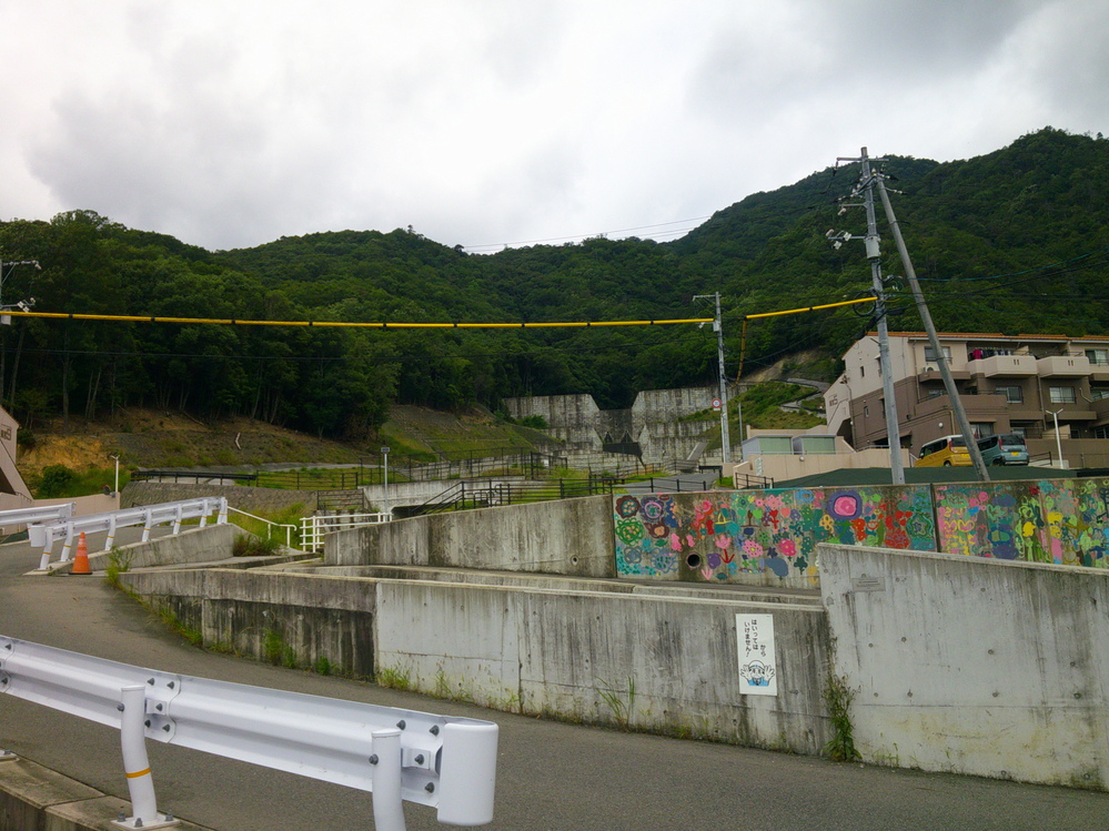 奥に八木地区の砂防堰堤、手前には壁面に描いた子供たちの絵が見える。